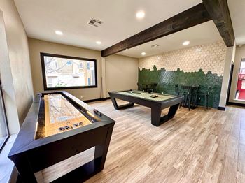 A room with a pool table and a shuffleboard table. at Ventana Oaks Apartments, Texas